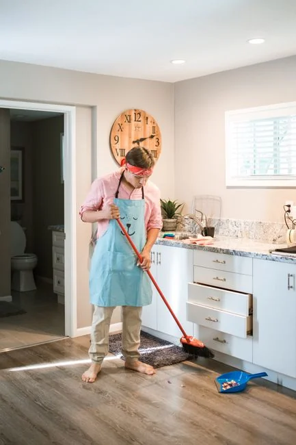 Un professionnel de l’entretien tenant une pile de serviettes propres dans une chambre d’hôtel haut de gamme, mettant en avant l’élégance et la qualité du service.